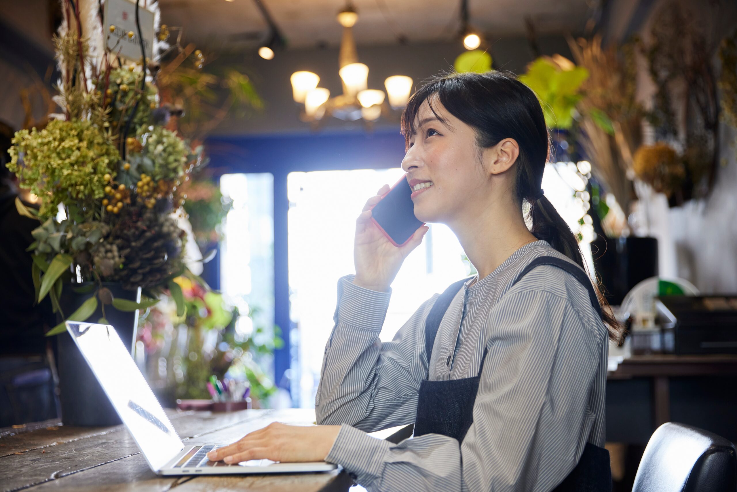 Japanese,Woman,Working,At,A,Flower,Shop,Using,A,Smartphone
