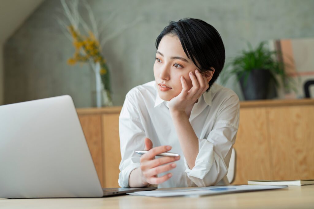 パソコンの前で悩んでいる女性
