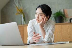 パソコンの前で悩んでいる女性