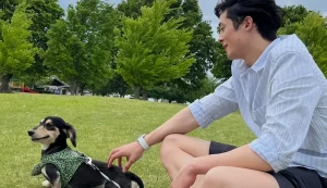公園で犬とくつろぐ男性