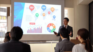 業績データをスクリーンに映して共有する社内会議