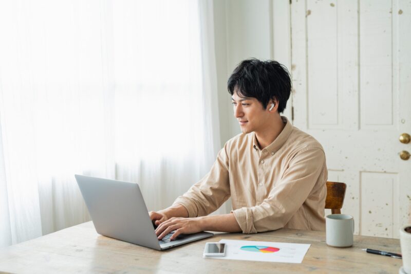 自宅でノートパソコンに向かって作業する男性