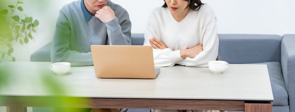 ノートパソコンで資金繰りを確認する男女
